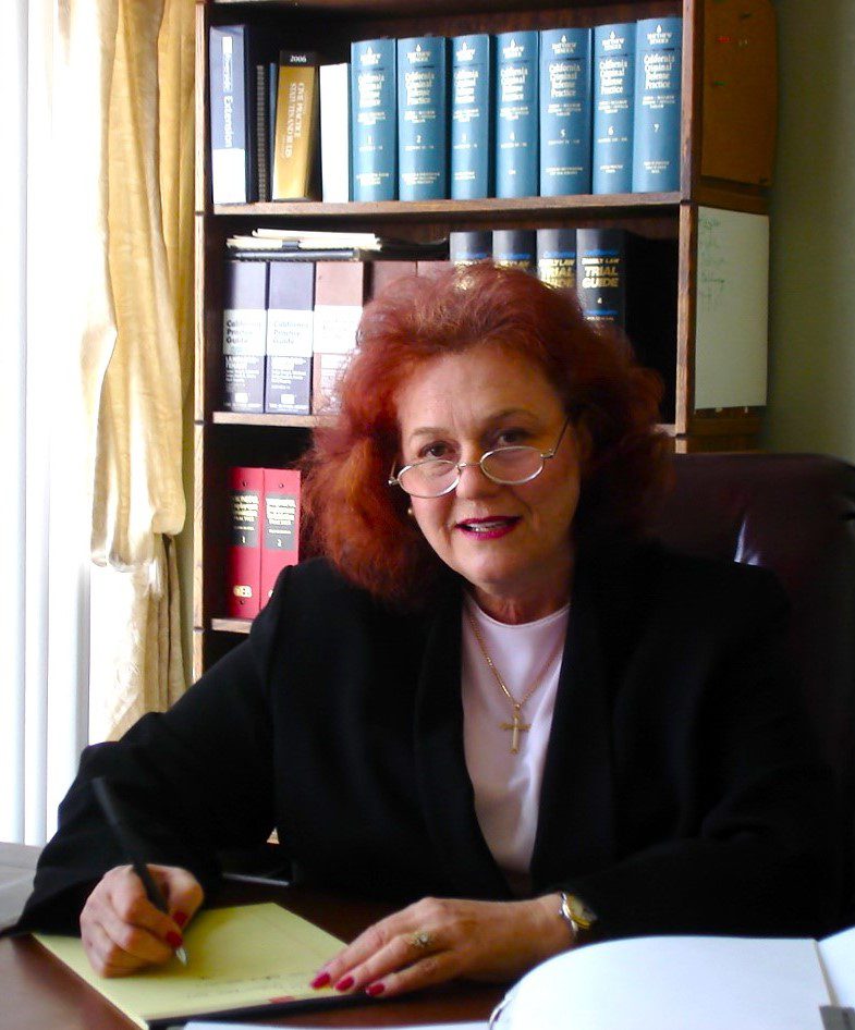 Red-haired woman writing at office desk